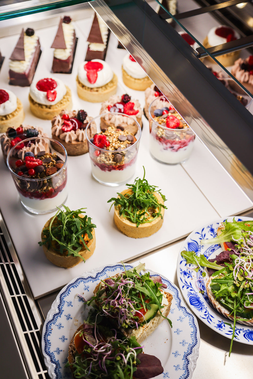 Glutenfreie Törtchen, glutenfreies Brot und Quiche, wie auch Joghurt stehen in der Vitrine vom Kardamom Cafe in Münster.